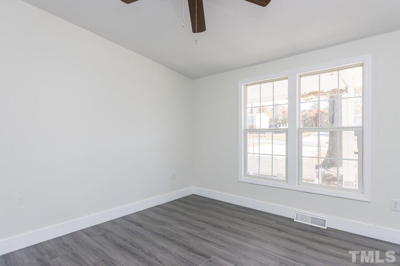 233 Eisler Drive Lillington, NC 27546 - Photo 14 of 29 an empty room with wooden floor and windows