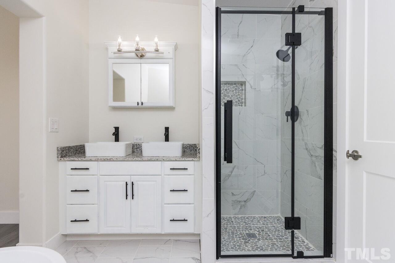 233 Eisler Drive Lillington, NC 27546 - Photo 15 of 29 a bathroom with a shower sink and mirror