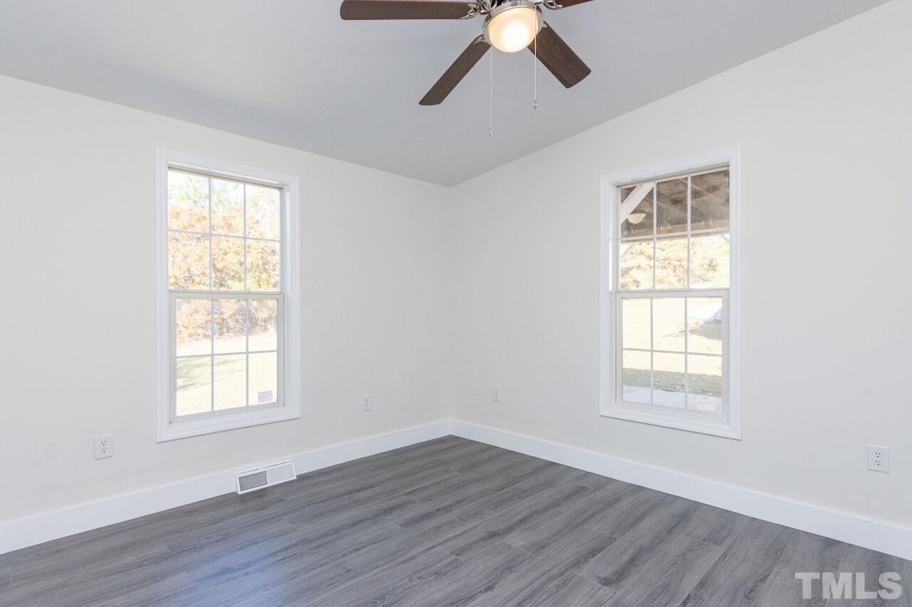 233 Eisler Drive Lillington, NC 27546 - Photo 18 of 29 a view of an empty room with wooden floor and window