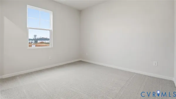 an empty room with a window and a kitchen