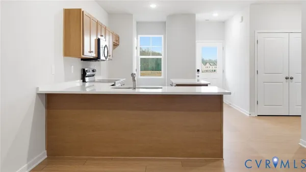 a kitchen with stainless steel appliances a sink a stove a microwave a counter top space and cabinets