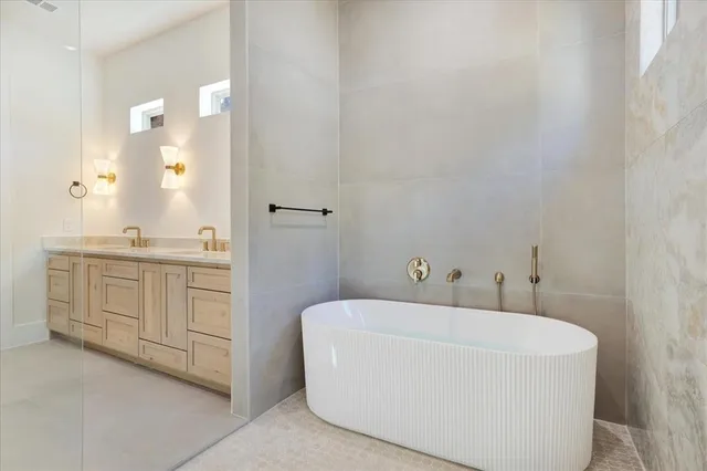 a bathroom with a bathtub a sink a vanity and a mirror