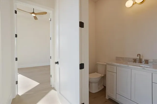 a bathroom with a granite countertop sink a toilet and shower