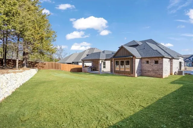 a view of a big house with a big yard and large trees