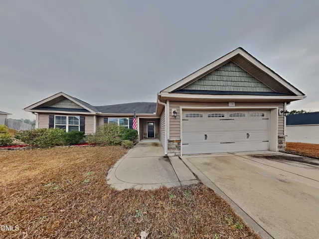 a front view of a house with a yard and garage