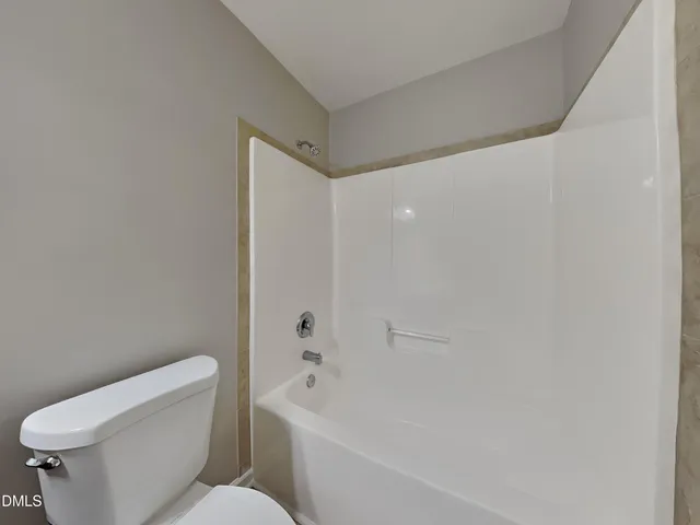 a white toilet sitting next to a bath tub