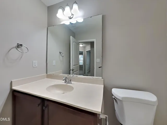 a bathroom with a sink a toilet and a mirror