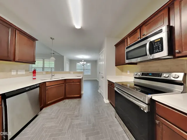 a kitchen with stainless steel appliances kitchen island granite countertop a stove sink and cabinets