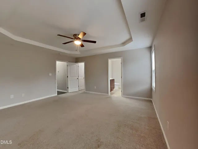 a view of an empty room with a ceiling fan