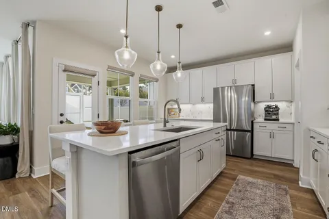 a kitchen with stainless steel appliances white cabinets and a stove top oven