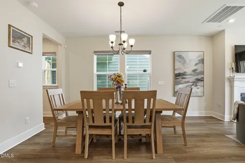 a view of a dining room and livingroom with furniture wooden floor a chandelier