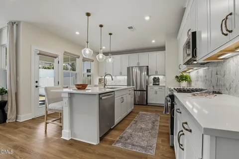 a kitchen with a stove a sink and a cabinets
