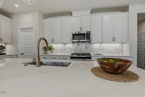 a kitchen with stainless steel appliances kitchen island granite countertop a stove a sink a dining table and chairs with wooden floor