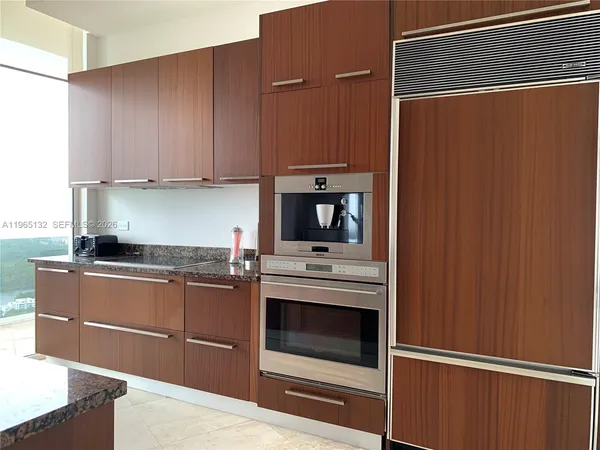 a kitchen with stainless steel appliances granite countertop a refrigerator and a stove top oven