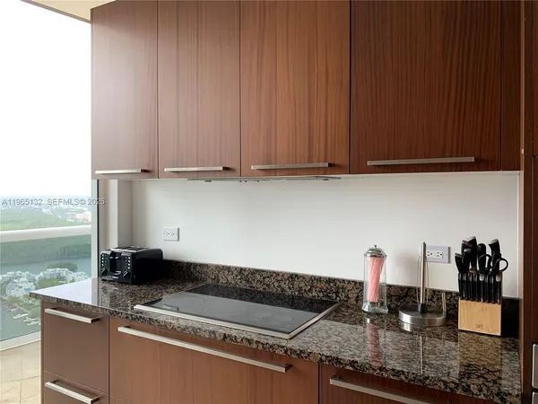 a kitchen with granite countertop a sink and a stove top oven