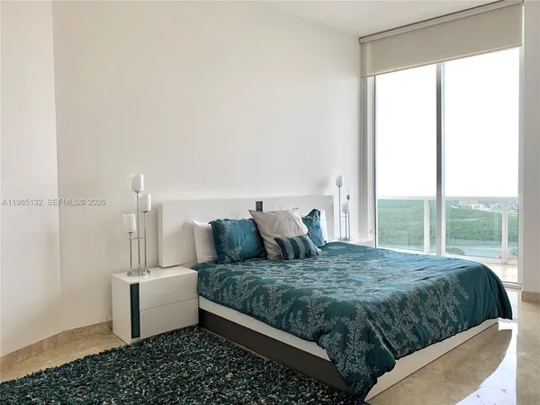 a bedroom with a large bed and a window