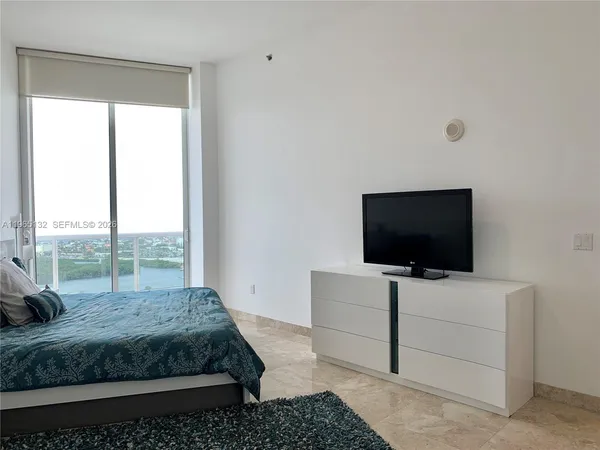 a bedroom with a bed and large window