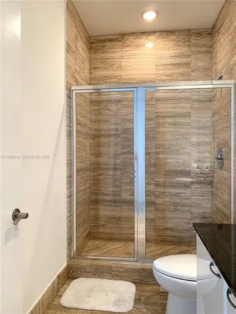 a bathroom with a toilet and a shower