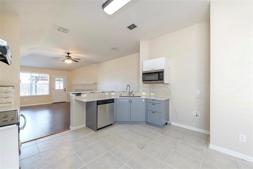 2716 Dawn Spring Drive Little Elm, TX 75068 - Photo 4 of 23 a large kitchen with a refrigerator a stove top oven and a dishwasher