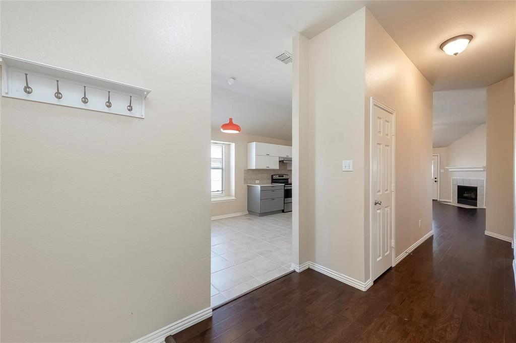 2716 Dawn Spring Drive Little Elm, TX 75068 - Photo 6 of 23 a view of a hallway with wooden floor and a kitchen