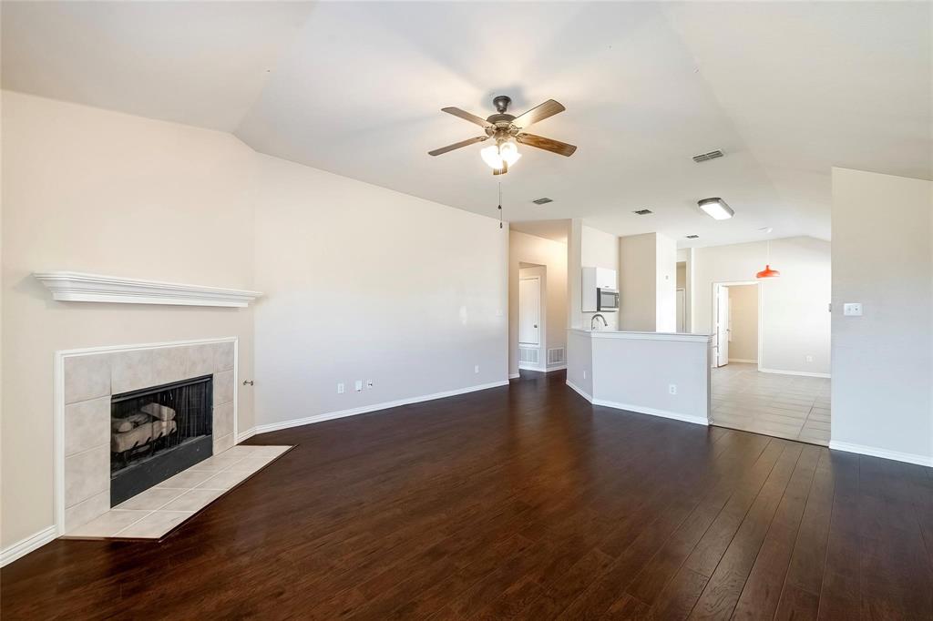 2716 Dawn Spring Drive Little Elm, TX 75068 - Photo 7 of 23 a view of a kitchen with a sink a fireplace and wooden floor