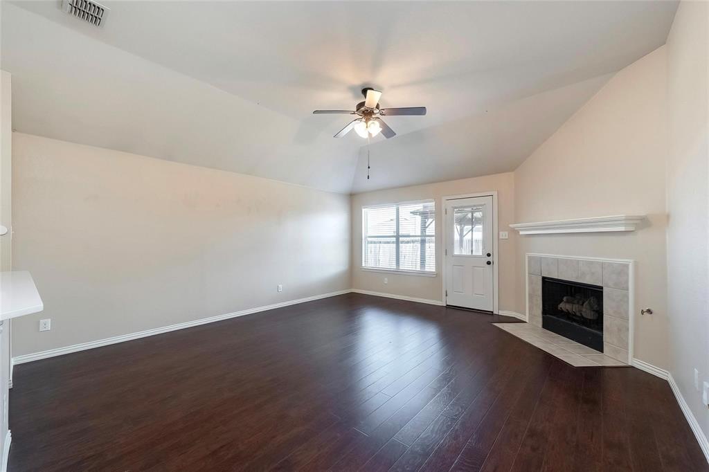 2716 Dawn Spring Drive Little Elm, TX 75068 - Photo 8 of 23 an empty room with wooden floor fireplace and windows