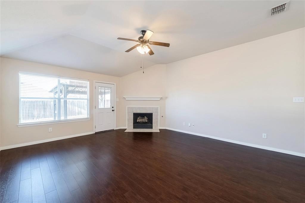 2716 Dawn Spring Drive Little Elm, TX 75068 - Photo 9 of 23 an empty room with wooden floor fan and windows