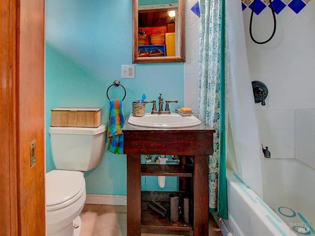 a bathroom with a sink a toilet a mirror a vanity and shower