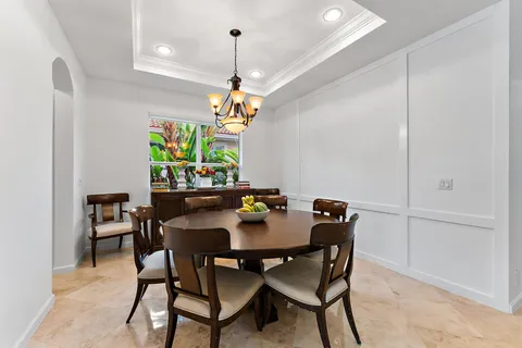 a dining room with furniture and a floor to ceiling window