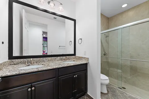 front view of a house with a yard and palm trees