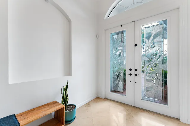 a large white kitchen with granite countertop a sink and white cabinets