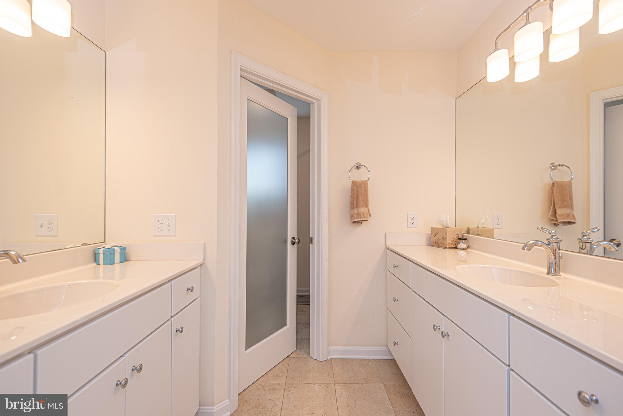 1502 Bay Street Fenwick Island, DE 19944 - Photo 33 of 62 a spacious bathroom with a double vanity sink and mirror