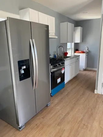a kitchen with stainless steel appliances a refrigerator stove and wooden floor