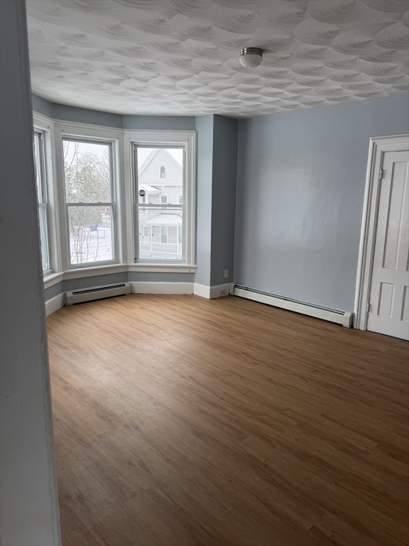 111 Bay, Unit 113 Springfield, MA 01109 - Photo 5 of 13 an empty room with wooden floor and windows