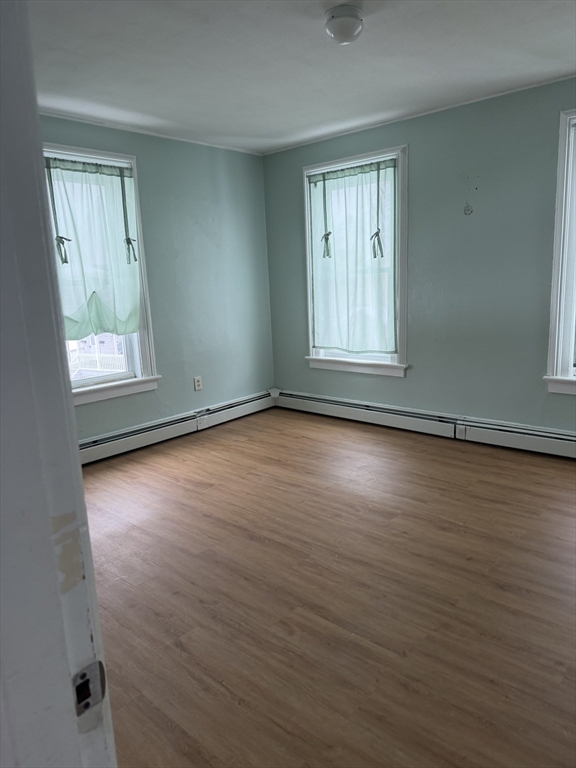 111 Bay, Unit 113 Springfield, MA 01109 - Photo 8 of 13 an empty room with wooden floor and windows