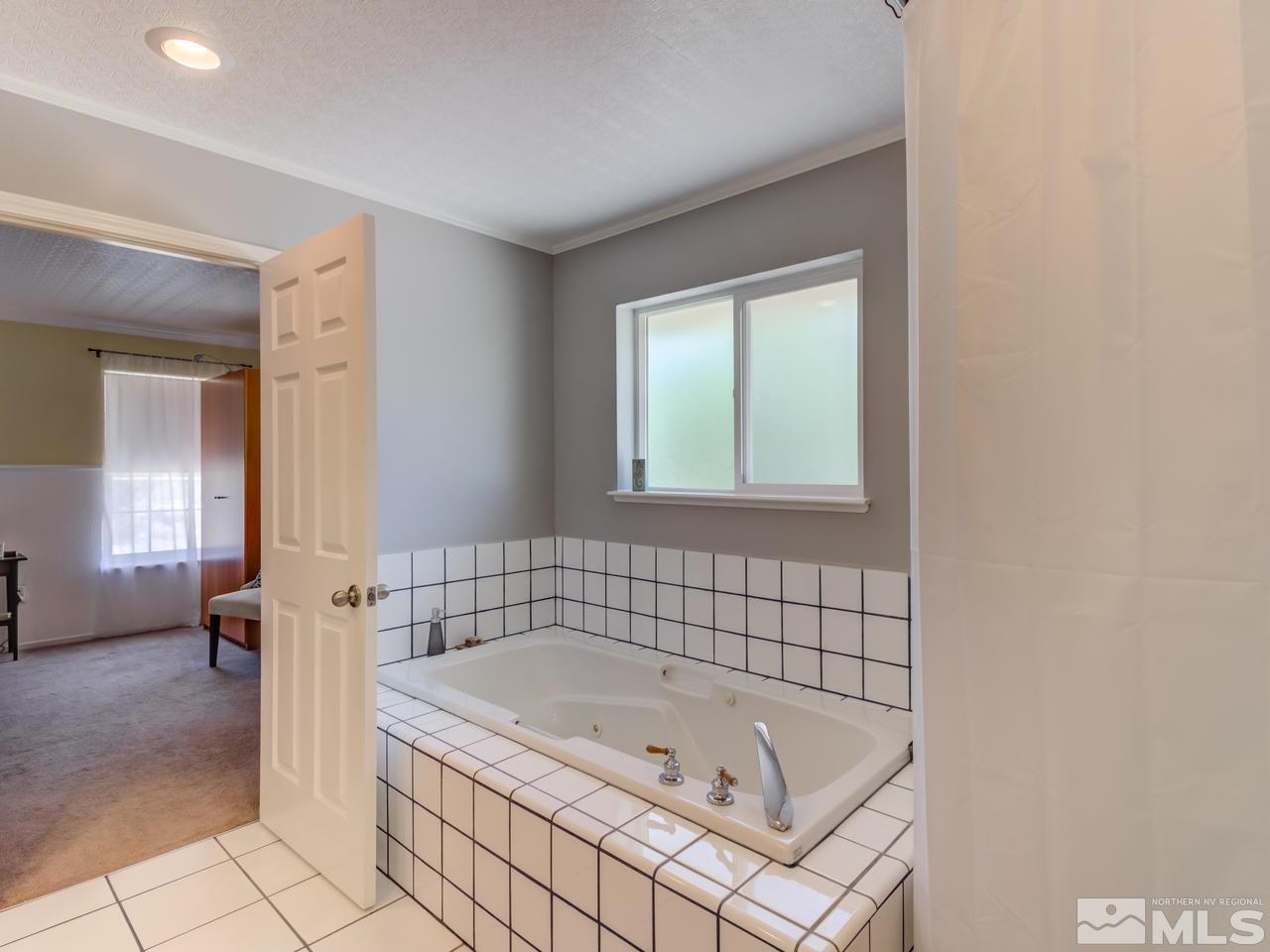 10570 Trailmaster Drive Reno, NV 89508 - Photo 12 of 25 a bathroom with a tub sink and mirror