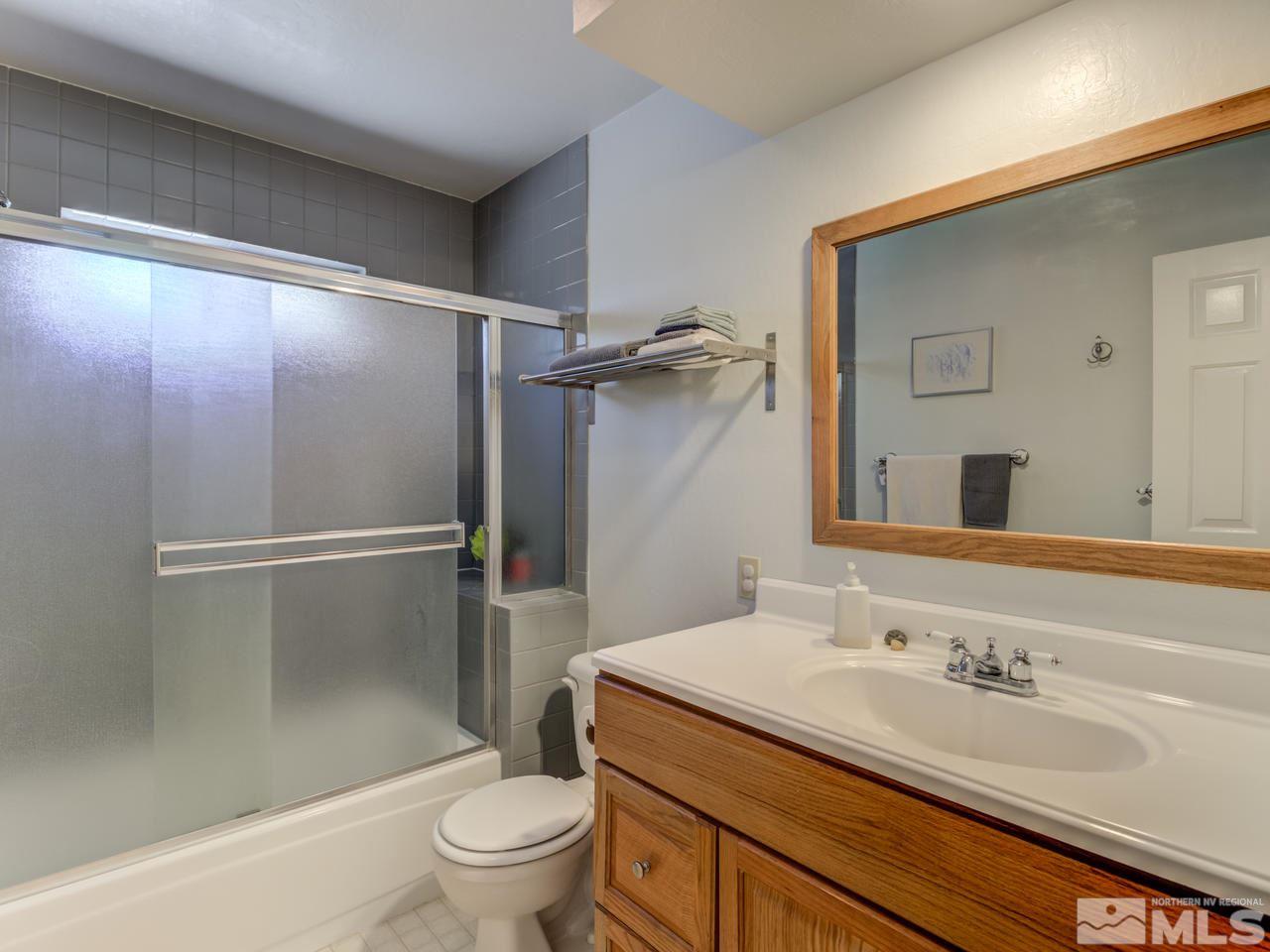 10570 Trailmaster Drive Reno, NV 89508 - Photo 16 of 25 a bathroom with a granite countertop sink toilet and shower