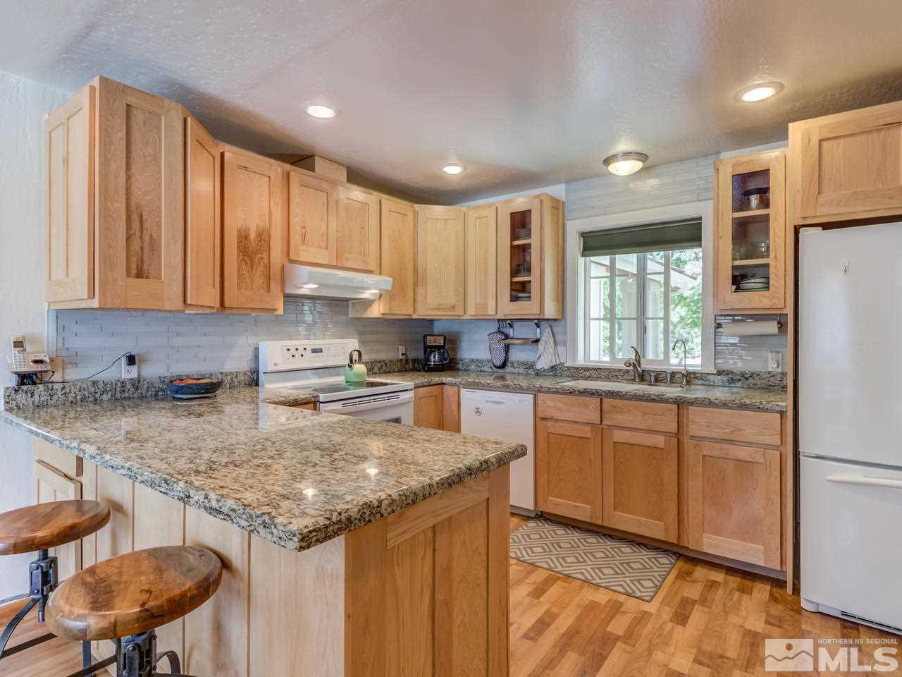 10570 Trailmaster Drive Reno, NV 89508 - Photo 6 of 25 a kitchen with stainless steel appliances granite countertop a stove a sink a refrigerator and a microwave