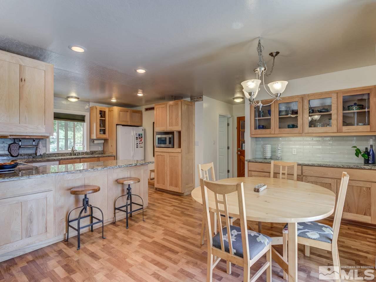 10570 Trailmaster Drive Reno, NV 89508 - Photo 8 of 25 a kitchen with stainless steel appliances kitchen island granite countertop a dining table chairs and granite counter tops