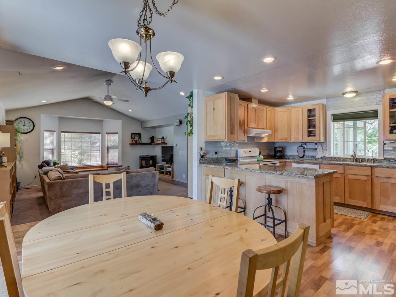 10570 Trailmaster Drive Reno, NV 89508 - Photo 9 of 25 a kitchen with counter top space cabinets dining table and stainless steel appliances
