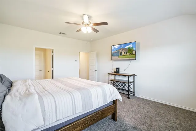 a bed sitting in a spacious bedroom next to a window