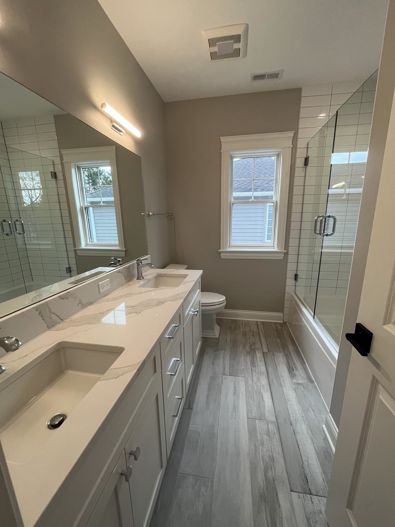 928 Hunter Road Glenview, IL 60025 - Photo 21 of 24 a bathroom with a sink a mirror and a shower