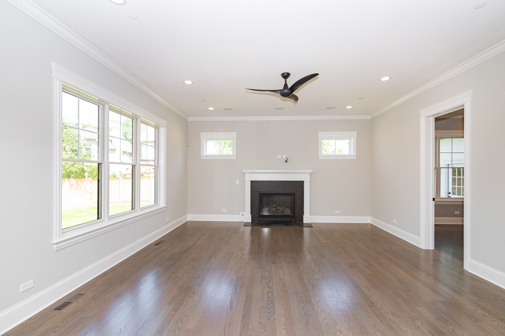 928 Hunter Road Glenview, IL 60025 - Photo 9 of 24 an empty room with wooden floor fireplace and windows