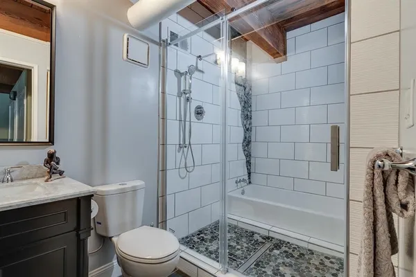 a bathroom with a sink a toilet and shower