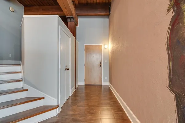 a view of a hallway with wooden floor and staircase
