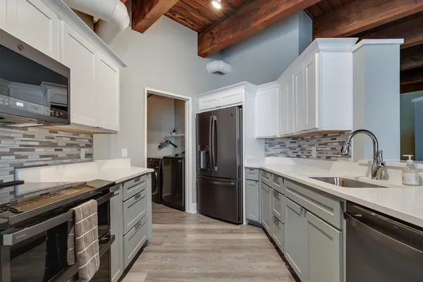 a kitchen with stainless steel appliances granite countertop a sink stove and refrigerator