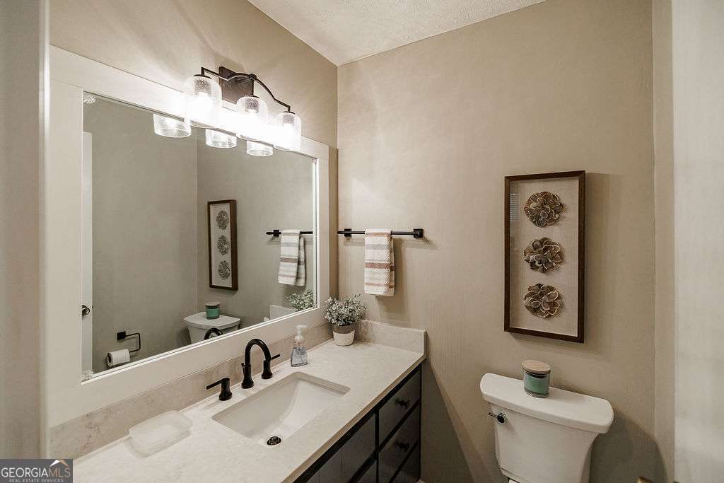 226 Baker Street Statham, GA 30666 - Photo 12 of 63 a bathroom with a sink and mirror with toilet