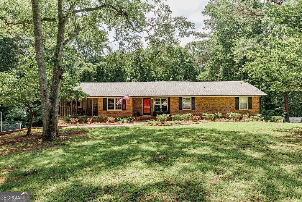 226 Baker Street Statham, GA 30666 - Photo 2 of 63 a front view of a house with a yard deck and trees