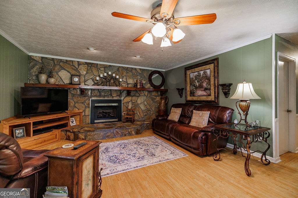 226 Baker Street Statham, GA 30666 - Photo 26 of 63 a living room with furniture a flat screen tv and a fireplace