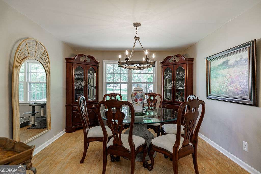 226 Baker Street Statham, GA 30666 - Photo 35 of 63 a dining room with furniture a chandelier and wooden floor